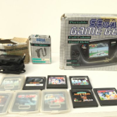 A boxed SEGA Game Gear portable game system. Includes manual. AC power supply. Car adaptor and 9 game cartridges. No reserve