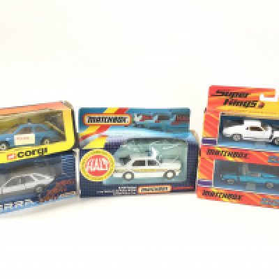 5 Boxed Diecast Cars Including A Matchbox Sierra. A Corgi Ford Escort. A Matchbox BMW And 2 Repro Mastangs.