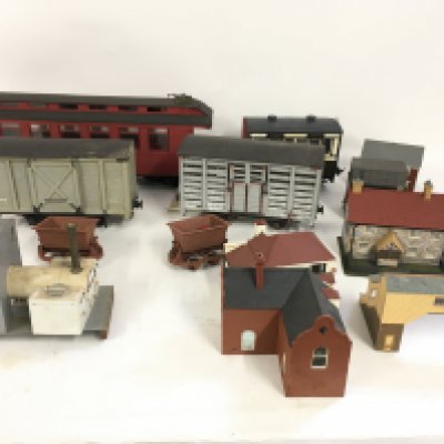 A collection of O gauge railway wagons and coaches plus a number of assembled and painted plastic buildings for scenery. No reserve.
