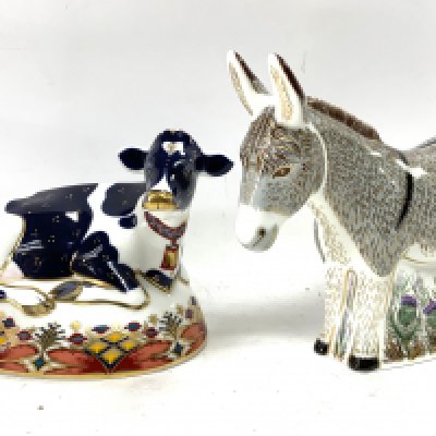A Royal Crown Derby figure of a Donkey together with Royal Crown Derby Frisian Cow, Buttercup. (Postage Catagory D, not avaliable in house).