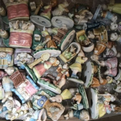 A box containing various ceramic bears and rabbits figure groups