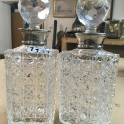 A pair of cut glass decanters with detachable stoppers and silver collars