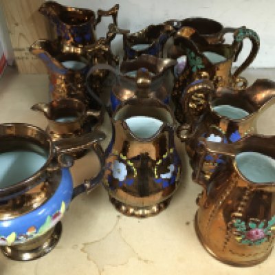 A collection of Victorian and later copper lustre jugs.