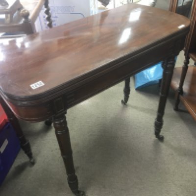 A late George III mahogany card table with a hinged top on turned legs.
