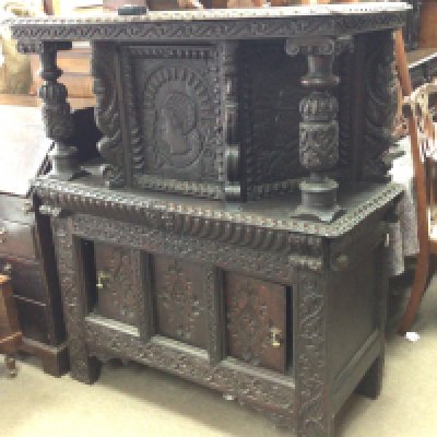 A 17th Century carved oak Court Cupboard the top section with carved pillars and a single cupboard above sliding doors. An interesting Court Cupboard with later alterations.116cm wide Hight 134cm