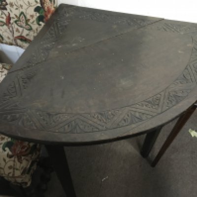 Victorian dark oak corner table with carved design, 70cm tall.