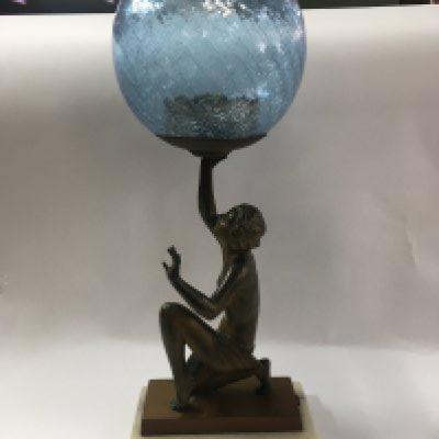 An Art Deco light in the form of lady with a glass shade.