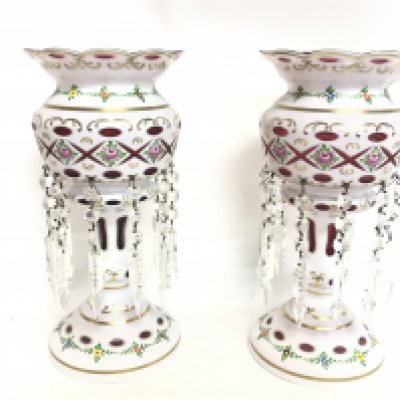 A pair of Victorian white and cranberry glass lustres with hand painted floral decoration, one damaged. 33cm tall. This lot cannot be posted