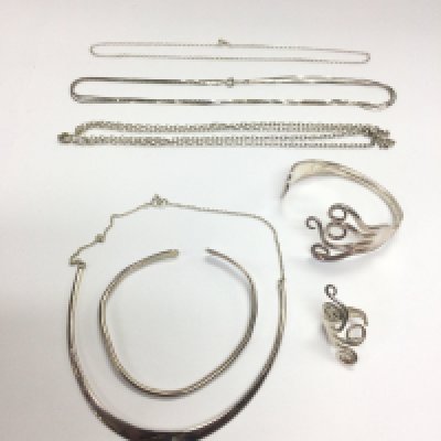 A collection of silver jewellery comprising a silver torque and chain, bangle, ring and chains. Shipping category A.- NO RESERVE