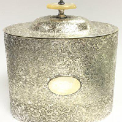An unusual silver plated tea caddy with raised decoration and mother of pearl handle, approximately 14cm tall. postage category C