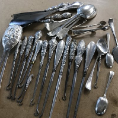 A collection of silver handled button hooks together with shoe horns, serving spoons, tea spoons various.