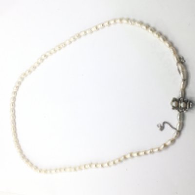 A pearl necklace with a silver clasp.