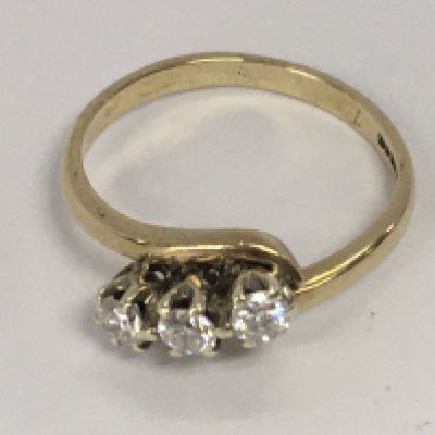 A 9ct gold ring inset with a row of three diamonds