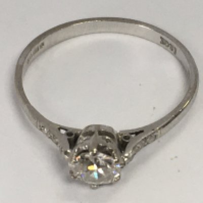 An 18ct white gold solitaire ring flanked by diamond chips