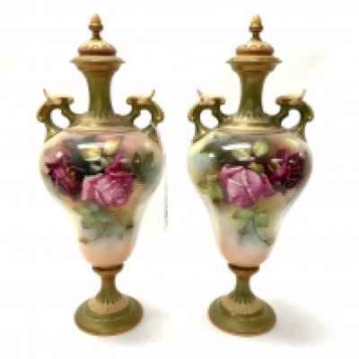 A Pair of Royal Worcester hand painted urns and covers with hand painted Rose decoration signed R.Austin. Height.32cm (D. in-house postage not available for this lot). No visible damage.