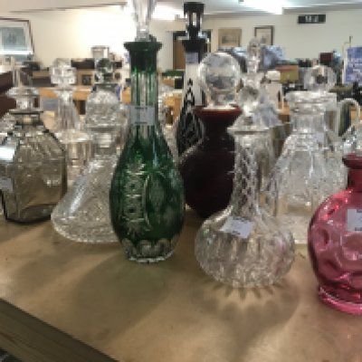 A large collection of mixed decanters including cut glass and coloured glass decanters and more. Approx 21 decanters.