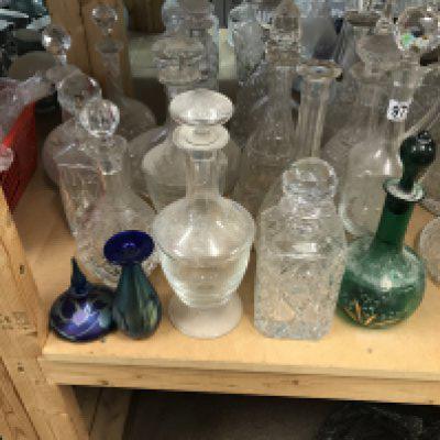 A large collection of decanters including some cut glass and alum bay and okra examples.
