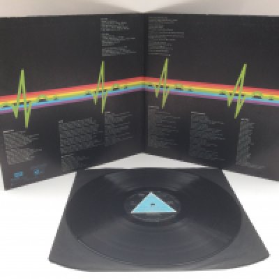 A first UK pressing of 'Dark Side Of The Moon' by Pink Floyd with solid blue triangle on labels. SHVL 804. Complete with inserts. No visible scratches. Wear to the label. Ringwear to sleeve and bumped and worn edges