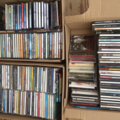 A box of CDs by various artists including Manic Street Preachers, Paul Weller, ELO and others.