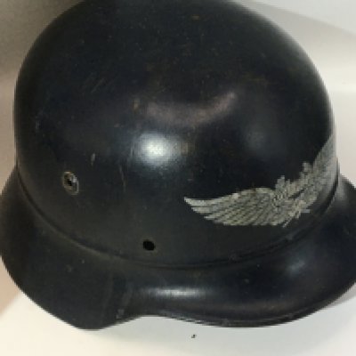 A German Third Reich Luftwaffe helmet with an unusual front decal double winged and central Luftwaffe with a raised press rib above the helmet peak. no lining. With stamped EF64 and 675.