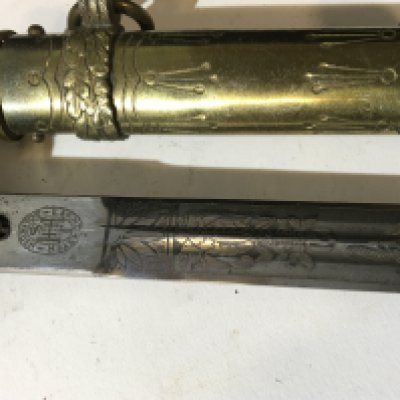A German Third Reich Kriegsmarine officers presentation dagger the decorated blade with makers marks brass scabbard with further ornamentation good condition.