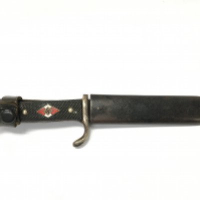 A Hitler Youth knife, by Anton Winger jr, Solingen. Blade etched with Blut und Ehre motto. With original scabbard. Blade 13cm long. Total length 24cm. This lot cannot be posted