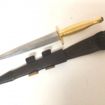 A Special issue Fairbairn Sykes fighting commando knife made by William Rodgers to commemorate the 50th Anniversary of Operation overlord. The blade with etched inscription the polished gold effect grip and T bar with makers stamp with a leather scabbed.