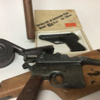 A replica Broom handled Mouser pistol (damaged) a replica German GSP 7.65 caliber pistol in original box a Japanese replica Winchester type under leave rifle and a Machine gun magazine with stamp marks.