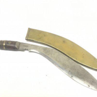 A Nepalese Kukri Knife with a wood handle the blade stamped Military supply with a brass scabbard.