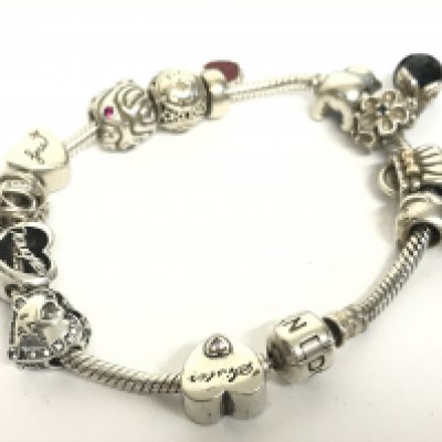 A silver Pandora bracelet with attached charms, postage category A