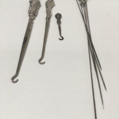 A collection of silver hair pins and button hooks.