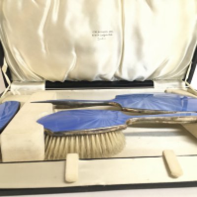A cased silver and enamel three piece dressing table set