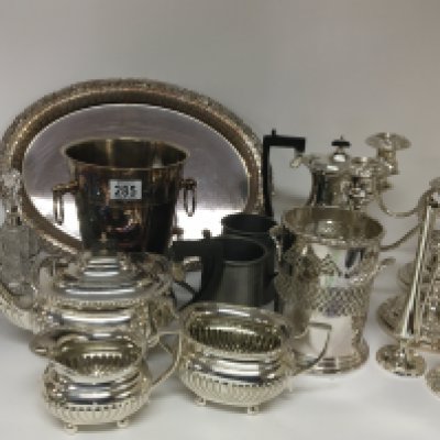A collection of silver plate comprising two condiment sets candelabra wine bucket a tray pewter tankards a tea set and other plated ware.