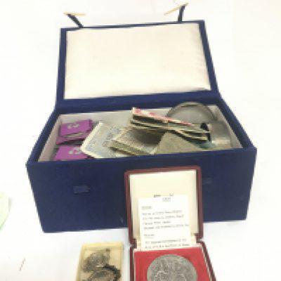 A box containing mixed coinage used bank notes and silver medals.