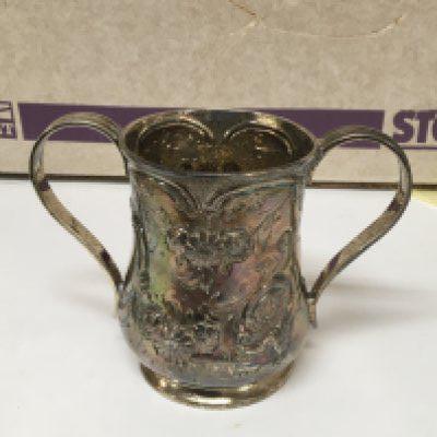 A silver two handled mug with repousse chasing. Marks to the base.