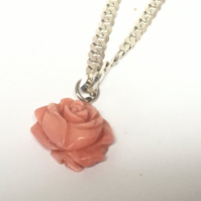 A silver necklace with carved coral pendant. Weight 22g