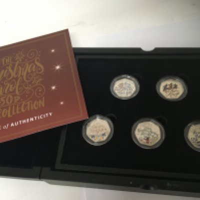 A cased set of silver Christmas Carol 50 pence coin collection. Five coins with certificate of Authenticity in a fitted box.