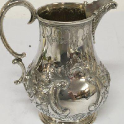 A Victorian silver jug with a scroll handle and repousse chasing London hallmarks height 12cm weight 240g