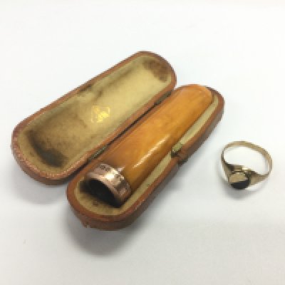 A 9ct gold ring and a cased gold and amber cigar holder (2). Shipping category A.