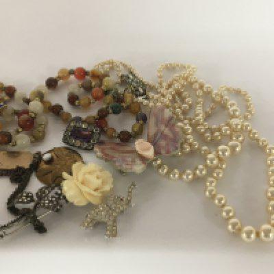A collection of costume jewellery a polished stone bead necklace and other ornaments.