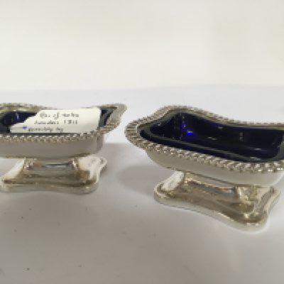 A pair of George III silver salts with blue glass liners and a gadroon pattern edge London 1811 hallmarks maker possible Stephen Adams.