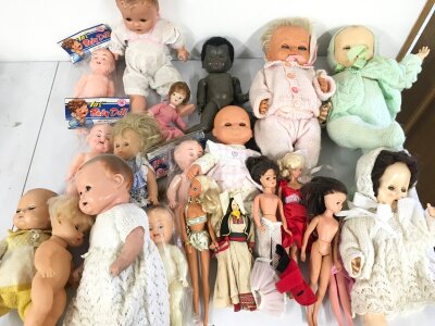 A large collection of assorted dolls.