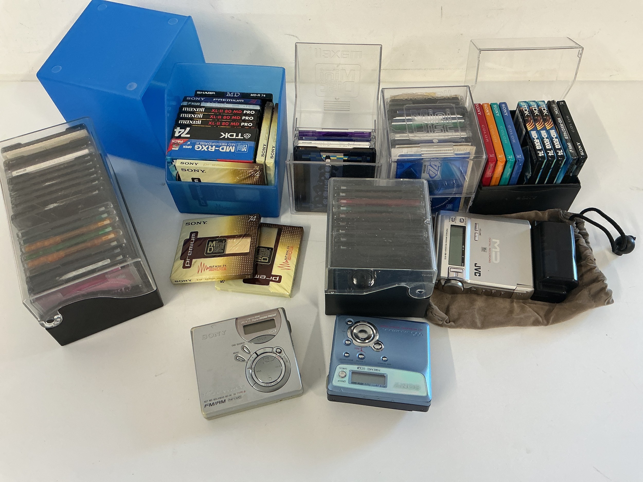 A collection of mini disc players and blank discs, some sealed.