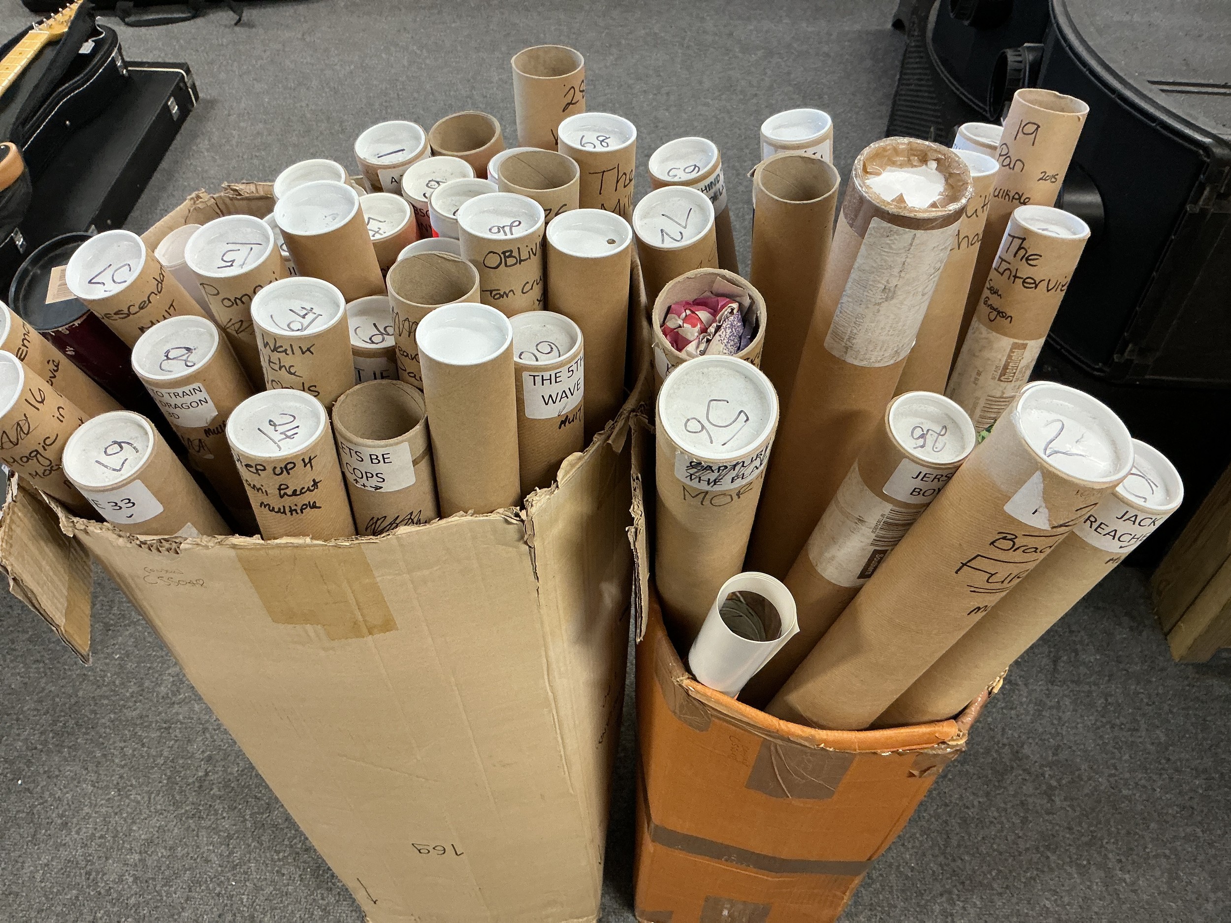 Two boxes containing a collection of film posters including Prometheus, Jack Reacher, Jersey Boys and others.