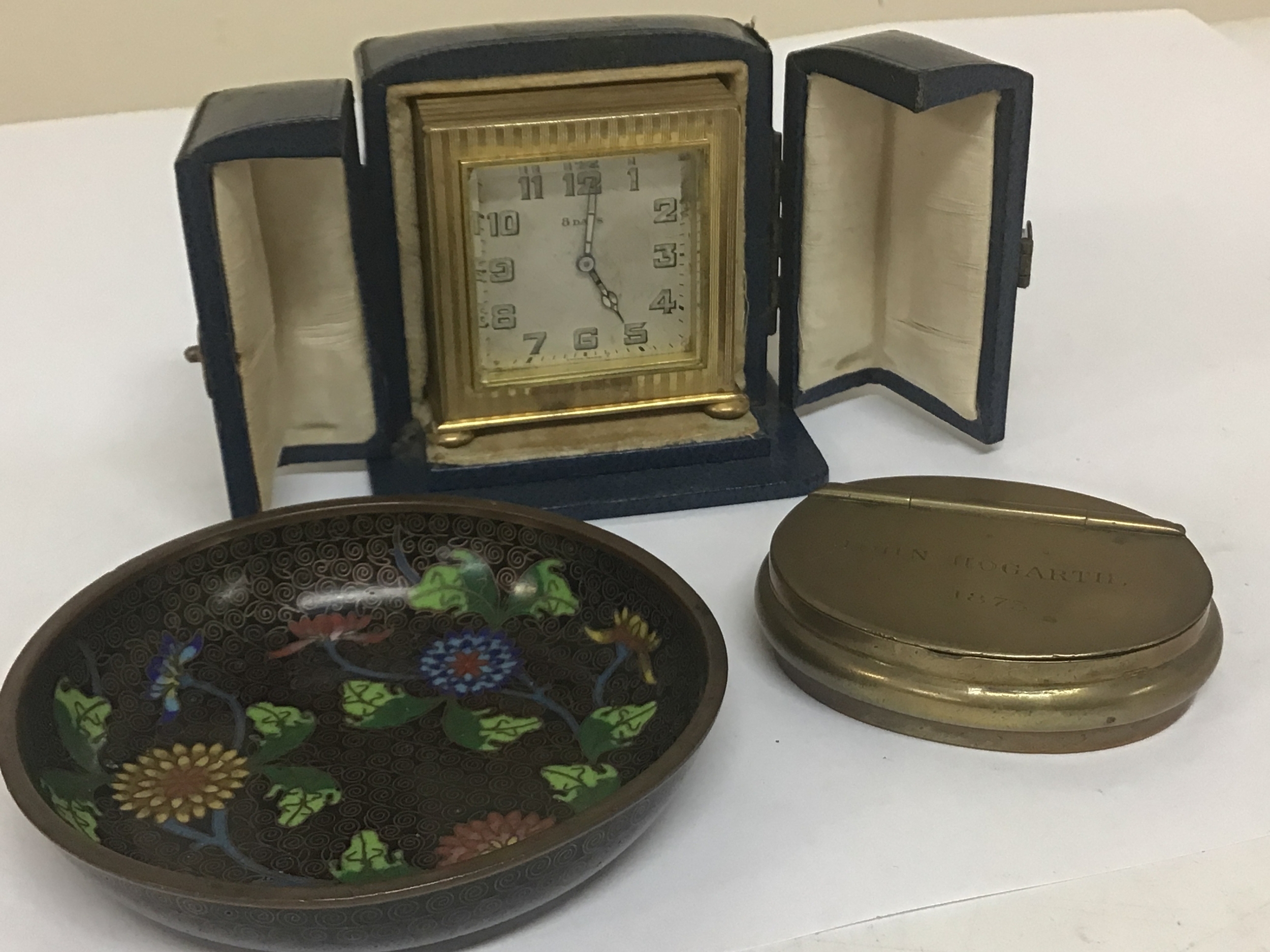  A small Swiss gilt cased travelling clock in a fitted case seen working  an enamel dish and a small snuff box with the inscription John Hogarth 1873. 