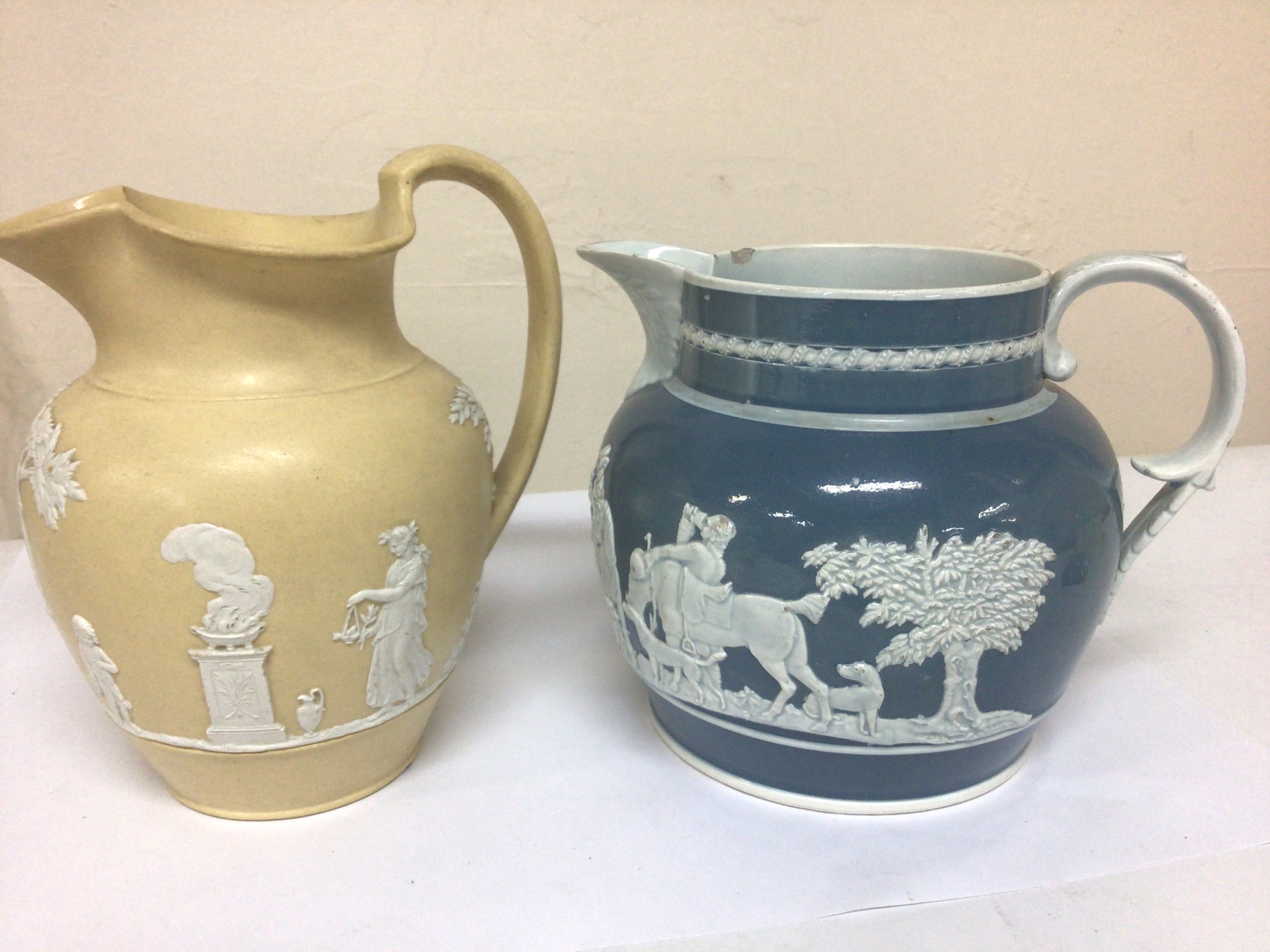  An Early 19th century yellow glazed jasper Wedgwood jug  sprig decorated with classic figures and one other 19th century jug (2) 