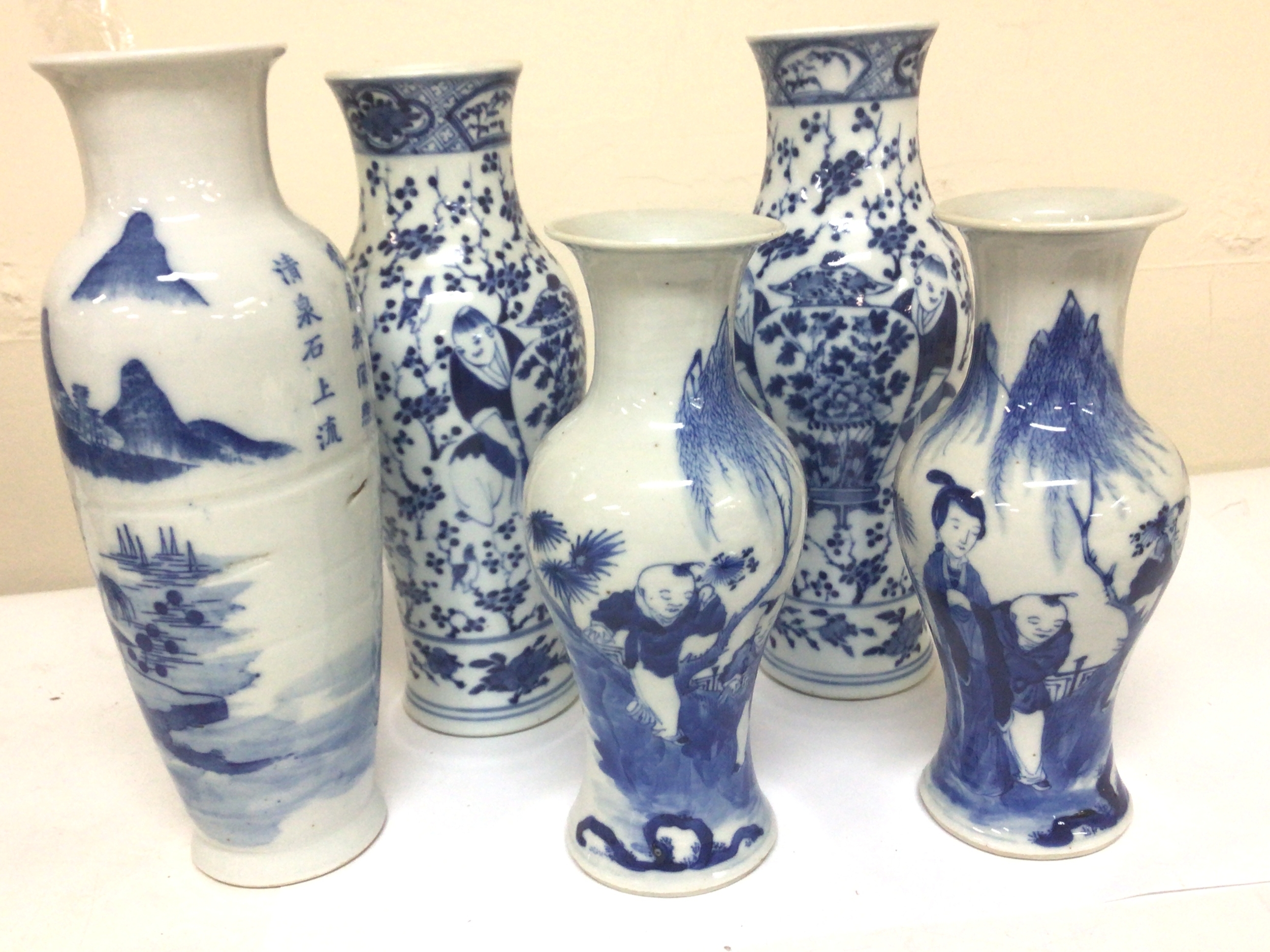 Two Pairs of Chinese Export porcelain vases blue and white decorated with figures caricature marks to the base the vase Quing Dynasty. Some professional restoration to the rim of the larger pair maximum height 25cm and one other export porcelain vase (5) 