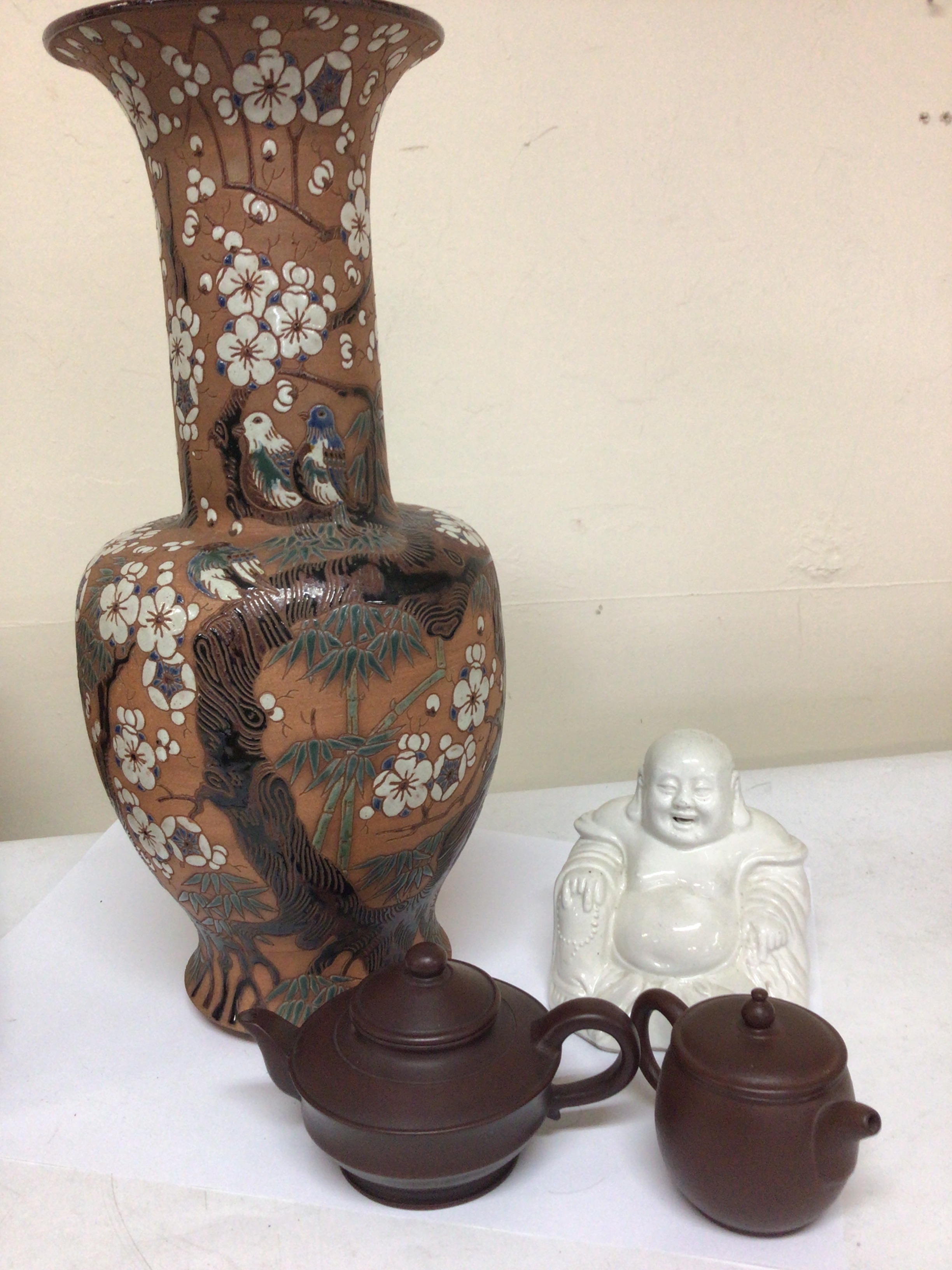 An interesting Japanese earthenware Vase decorated with birds amongst cherry blossom. Impressed marks to the base 20th century no obvious damage height 43cm two small terracotta Chinese tea pots and a ceramic seated Buddha figure. (4)
