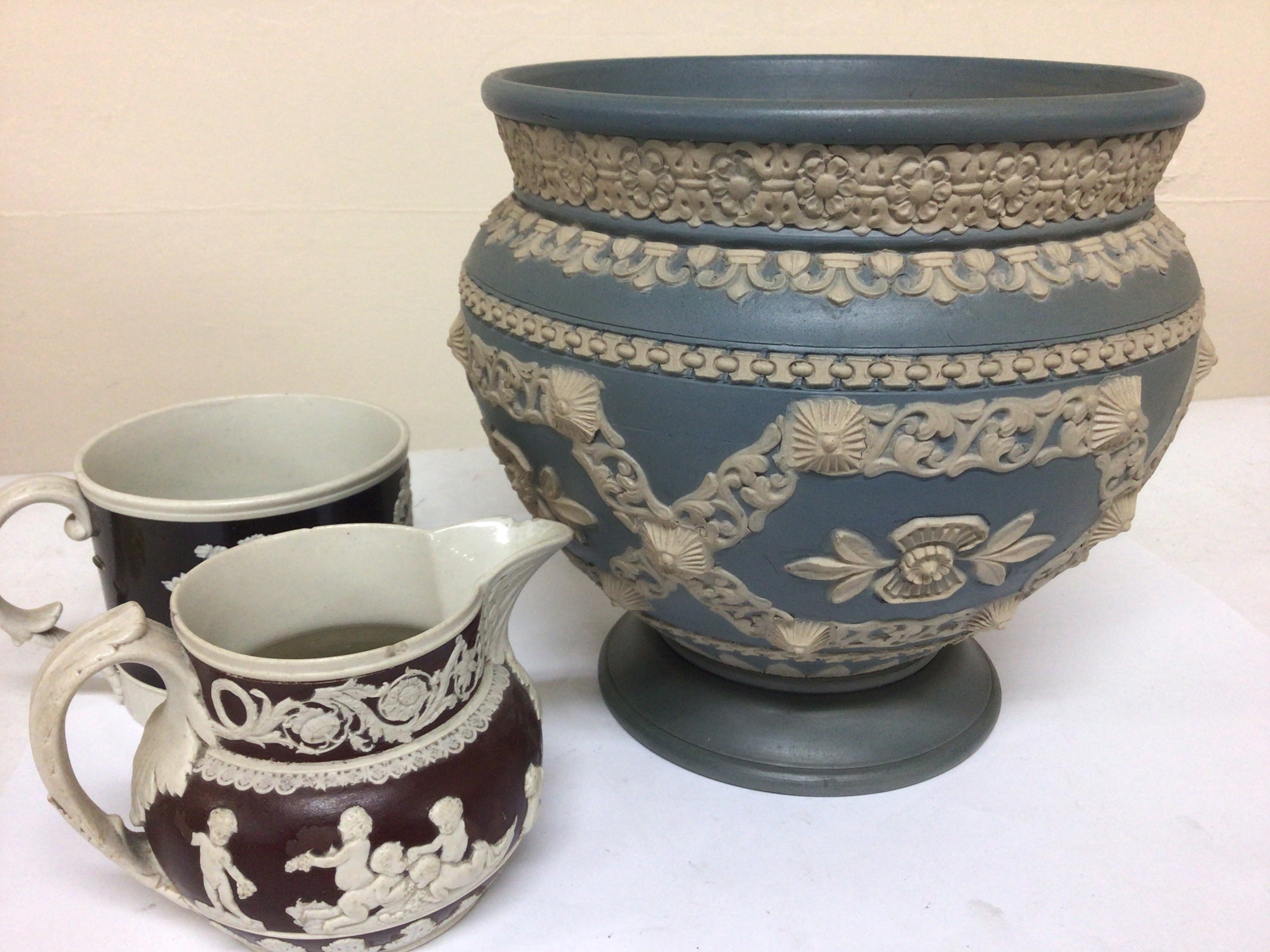  A Victorian Lambeth Doulton jardiniere with raised decoration on a pale blue ground a 19th century Spode jug and conforming cup 