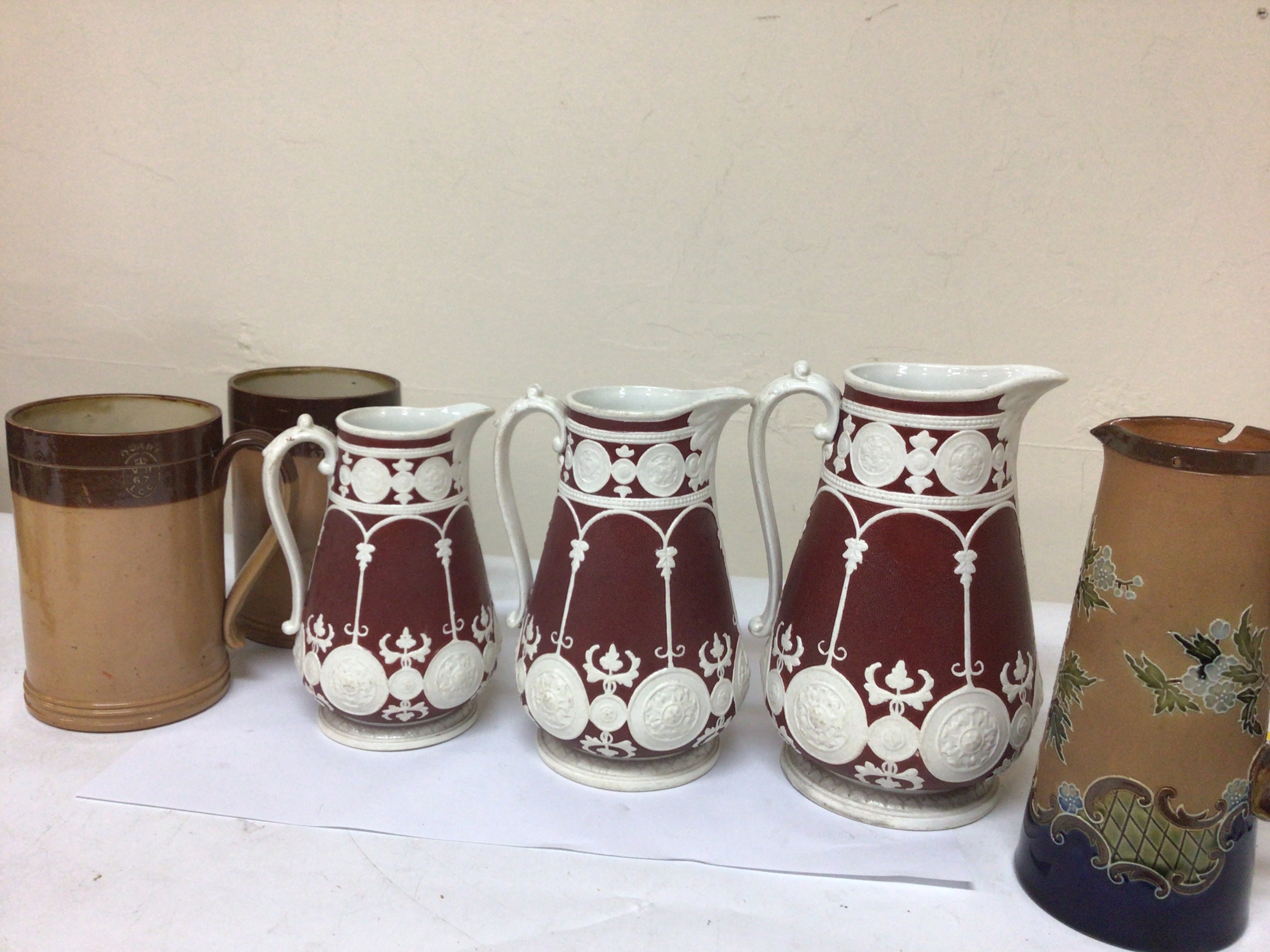  A set of three Graduating Victorian jugs with Victorian date letter Lozenge, two Victorian stoneware Quart mugs and a Royal Doulton jug. Maximum high 23cm. 
